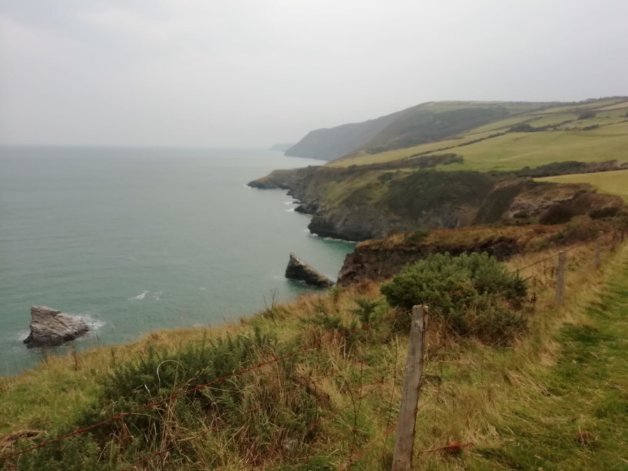 View of the Wales Coas Path, a walking trail, cliffs and the sea.